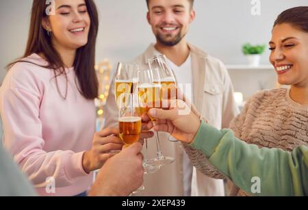 A group of smiling young people toast while standing, close-up Stock Photo