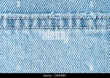 Blue denim jeans pants cloth with seam, close up, macro. Fabric texture wallpaper, backdrop, design detail. Stock Photo