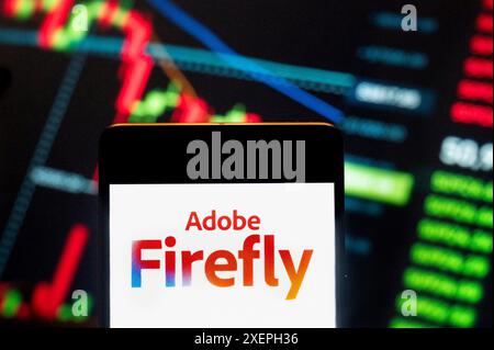 In this photo illustration, the generative machine learning model included as part of Adobe Creative Cloud, Adobe Firefly, logo seen displayed on a smartphone with an economic stock exchange index graph in the background. (Photo by Budrul Chukrut / SOPA Images/Sipa USA) *** Strictly for editorial news purposes only *** Stock Photo