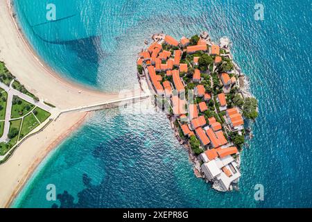 Aerial view of Montenegro's Sveti Stefan, showcasing its iconic orange rooftops, stunning coastline, and luxurious seaside resort against the beautifu Stock Photo