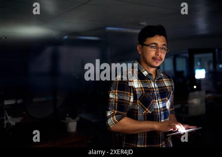 Man, developer and tablet in office at night for software development, coding and code analytics. Male programmer, digital and process script Stock Photo