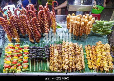 Hoi An, Vietnam - 5 Feb, 2024: Grilled octopus and meat skewers sold as snacks from a street vendor in Hoi An night market Stock Photo