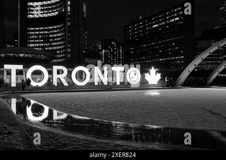 Toronto's main ice skating rink is in front of the city hall building at Nathan Philips Square. This large Toronto Sign is a city icon for tourists. Stock Photo