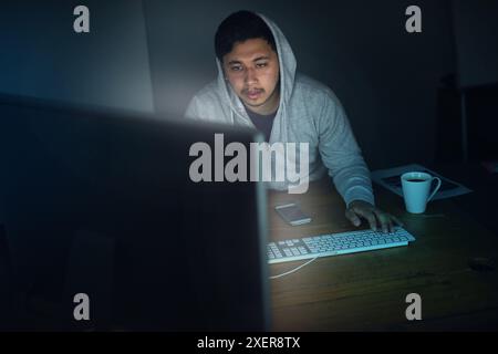 Man, hacker and tired with computer in night for programming, software and working on project for system breach. Cybersecurity, dark and network for Stock Photo