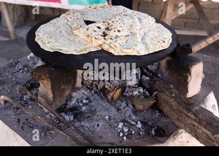 Cooking kutabs on a hot iron over coals. Baku. Azerbaijan. Stock Photo