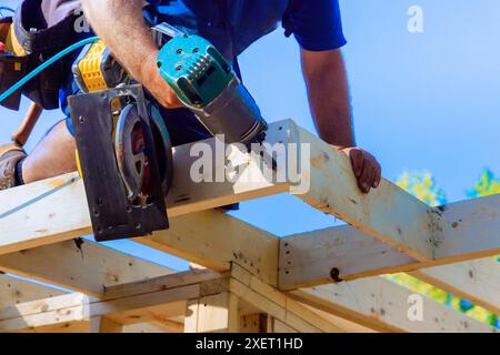 An air nail hammer is used by framing contractor to nail wooden beams ...