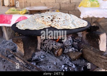 Cooking kutabs on a hot iron over coals. Baku. Azerbaijan. Stock Photo