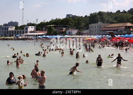 People relax by the water and swim on Lanzheron Beach. Hot summer day near the Black Sea. People escape the heat through relaxing by the water. Stock Photo