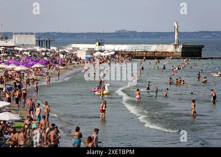 People relax by the water and swim on the beach 'At the Yellow Stone' Hot summer day near the Black Sea. People escape the heat through relaxing by the water. Stock Photo