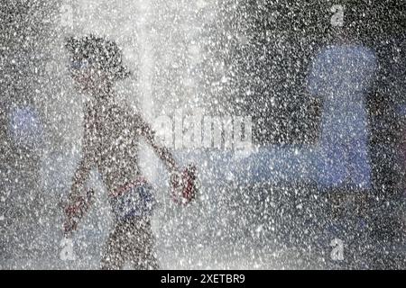 People relax by the water and swim on Lanzheron Beach. Hot summer day near the Black Sea. People escape the heat through relaxing by the water. Stock Photo