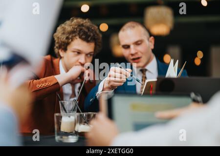 Business meeting with two colleagues collaborating on a project over coffee Stock Photo