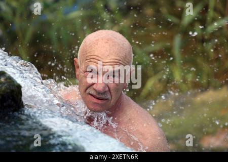 Odessa, Ukraine. 29th June, 2024. A man bathes in underground water on the beach 'At the Yellow Stone' Hot summer day near the Black Sea. People escape the heat through relaxing by the water. (Photo by Viacheslav Onyshchenko/SOPA Images/Sipa USA) Credit: Sipa USA/Alamy Live News Stock Photo