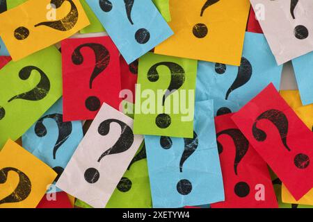 Too Many Questions. A pile of colorful paper notes with question marks on them. Close up. Stock Photo