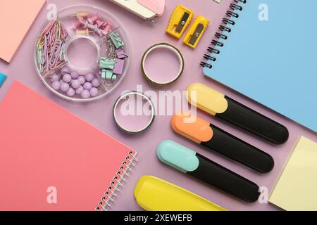 Flat lay composition with notebooks and different stationery on violet background Stock Photo