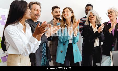 Diverse business team celebrating success in an office. Corporate team applauding and showing appreciation. Professional colleagues clapping together Stock Photo