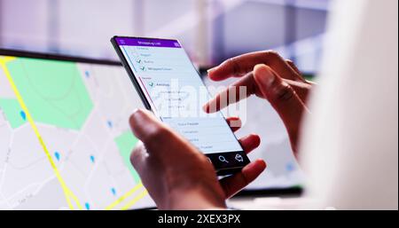 Busy African American Woman Using Grocery Shopping List Mobile App on Her Smart Phone in Supermarket Stock Photo