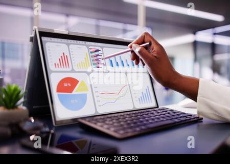 Innovative African American Data Analyst Maximizing Business Performance Through Data Analytics on Laptop in Office Stock Photo