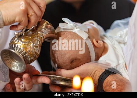 Infant baptism. Water is poured on the head of an infant.for design purpose Stock Photo