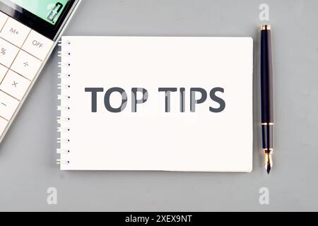 The phrase Top Tips in a notebook on a gray background Stock Photo