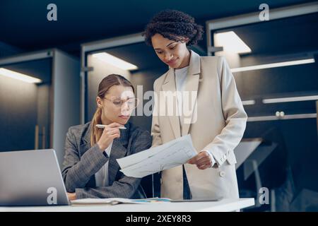 Female boss discussing project with employee showing presentation to team leader Stock Photo