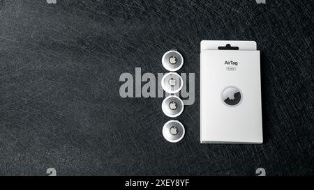 Jurmala, Latvia 25.06.2024: A box of Apple airtag is placed on a sleek black surface Stock Photo