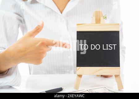 A woman pointing at a blackboard with the word to do list written on it Stock Photo