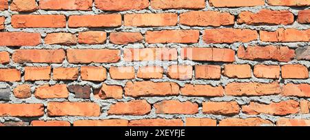Old brick wall texture, background. The fragment of bad and dirty bricklaying with cement smeared bricks. Uneven brickwork and wall backdrop Stock Photo