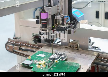automated machine assembling a circuit board, reflecting the precision and efficiency of modern manufacturing technology. Stock Photo