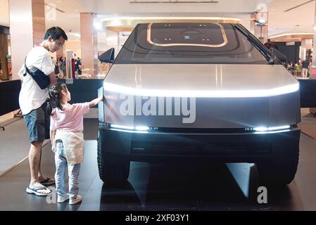 Bangkok, Thailand. 30th June, 2024. Visitors inspect a Tesla Cybertruck car during the event at Central World the shopping mall. Tesla launched a campaign 'Cybertruck Tour' in Thailand aimed to promoted its Tesla Cybertruck car around Thailand. Tesla planned to hold this campaign around Thailand including Bangkok, Khon Kaen and Chiang Mai. Credit: SOPA Images Limited/Alamy Live News Stock Photo