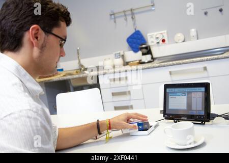 Person using a personal medicine assistant  The person brings the medicine closer to the reader in order to know if that medicine should be taken in t Stock Photo