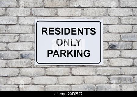 Residents only parking sign on wall at private housing development Stock Photo