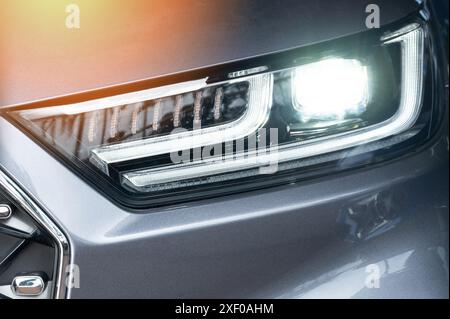 Led headlight on modern gray color car macro close up view Stock Photo
