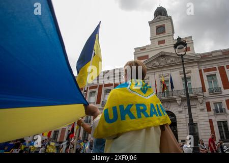 Madrid, Spain. 30th June, 2024. A woman carries a flag during a pro-Ukrainian rally. Ukrainian residents in Madrid meet every week in the center of the Spanish capital to support their compatriots at war and raise financial funds to send to their relatives punished by the war. Credit: SOPA Images Limited/Alamy Live News Stock Photo