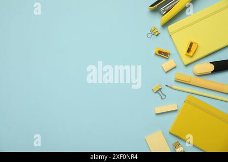 Flat lay composition with notebooks, stapler and different stationery on light blue background, space for text Stock Photo