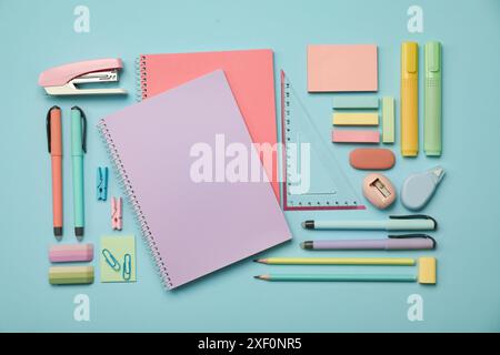 Flat lay composition with notebooks, stapler and different stationery on light blue background Stock Photo