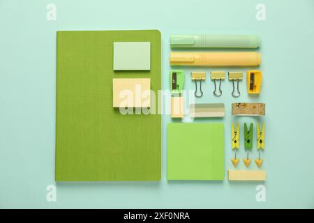 Flat lay composition with notebooks and different stationery on turquoise background Stock Photo