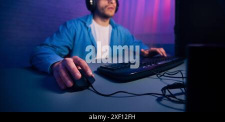 Man Using Computer Mouse and Keyboard While Gaming at Night Stock Photo