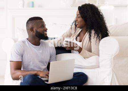 Couple Relaxing on Couch With Laptop Stock Photo