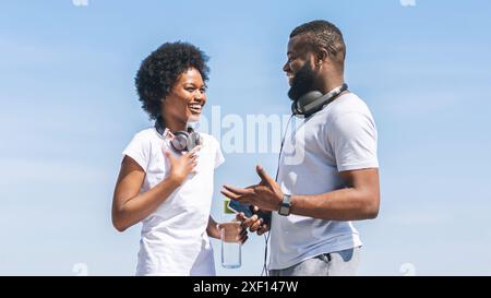 African American Woman Discussing Jogging Program With Coach Outside Stock Photo