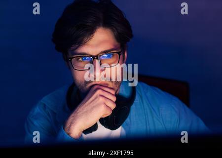 Man Wearing Glasses Contemplates Work in Front of Computer Stock Photo