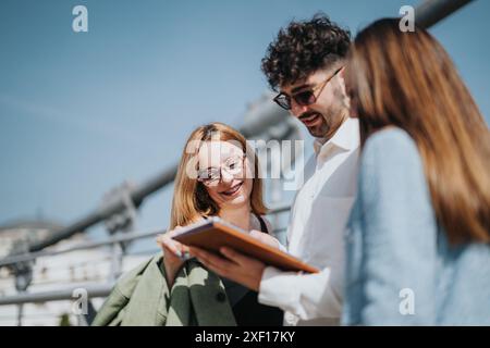Young professionals engaging in a collaborative outdoor meeting on a sunny day Stock Photo