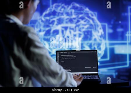 Admin writes code on laptop to visualize artificial intelligence neural networks made up of interconnected nodes using augmented reality technology. Expert running AI script for data processing Stock Photo