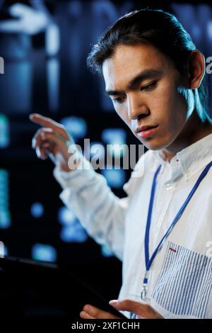 Tech support worker between server cabinets electronics providing processing resources for companies worldwide. Competent developer fixes facility supercomputers used for storing large databases Stock Photo