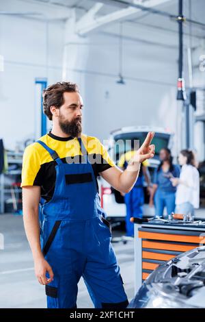 Serviceman repairing a car using augmented reality application Stock ...