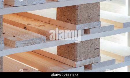 A stack of wooden pallets with a brick base. The pallets are stacked on top of each other, creating a sturdy base. Concept of strength and durability Stock Photo