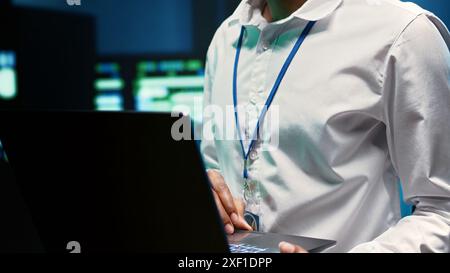 Experienced engineer in data center fixing network issues affecting server performance and connectivity, leading to slow transfer rates and poor client communication, close up Stock Photo