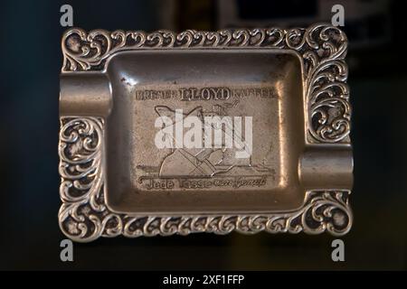 A silver-plated ashtray bears the embossed slogan "Bremer Lloyd Kaffee – Jede Tasse ein Genuss" ("every cup a pleasure"), a historic promotional item of the Bremen coffee roaster Lloyd Caffee. Hagstraße, Bremen, Germany. Stock Photo