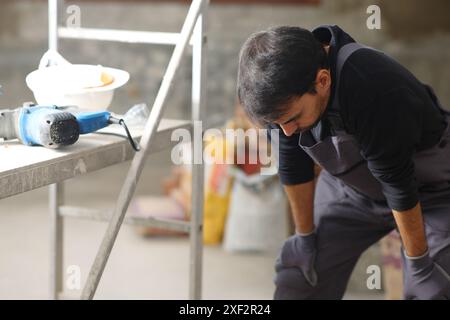 Exhausted construction worker resting in a house under renovation Stock Photo
