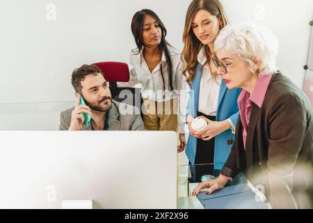 A diverse group of business professionals collaborating in an office meeting. Teamwork and strategy discussion with a focus on planning and brainstorm Stock Photo