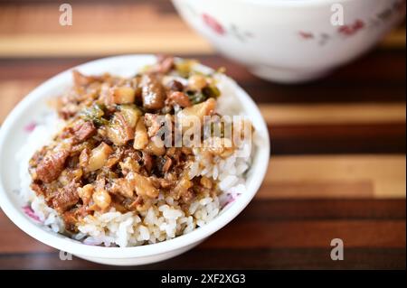 Braised pork rice is a classic Taiwanese snack featuring savory minced pork over fluffy rice, served in ceramic bowls for added rustic flavor. Stock Photo